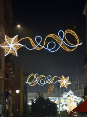 Decoración navideña con estrellas y cintas iluminadas en un cielo nocturno.