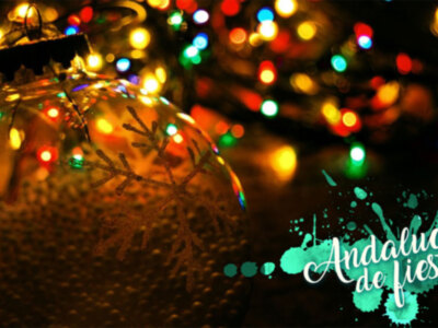 Bola de Navidad con luces multicolores en el fondo. Texto: Andalucía de fiesta.