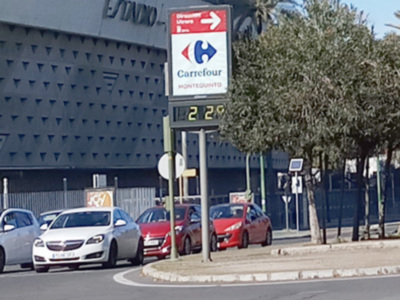 Señal de Carrefour Montegranito en una intersección con coches en movimiento.