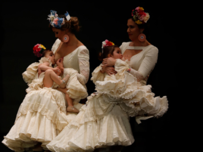 Tres bailarinas en trajes de flamenca danzan con gestos expresivos, destacándose sus vestidos blancos y adornos florales.
