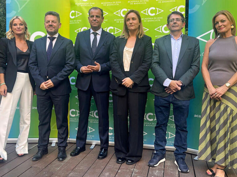 Grupo de personas posando frente a un fondo verde con el logo de CTA.