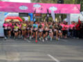 Corredoras en una carrera de maratón, con la línea de meta y publicidad al fondo.